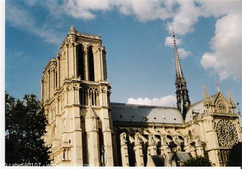 Notre-Dame Cathedral in Paris, Gothic stone tower under a cloudy sky