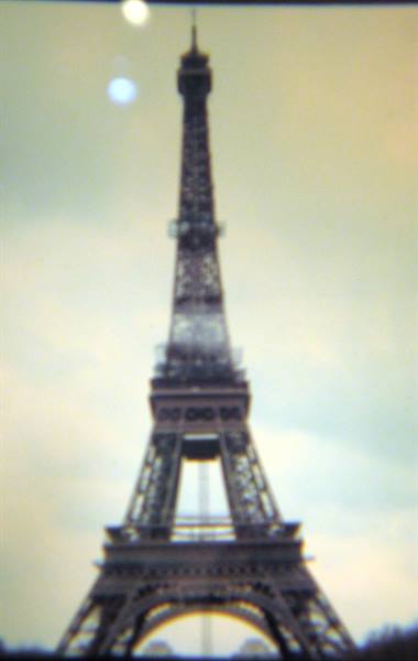 The Eiffel Tower's iron lattice against an overcast sky