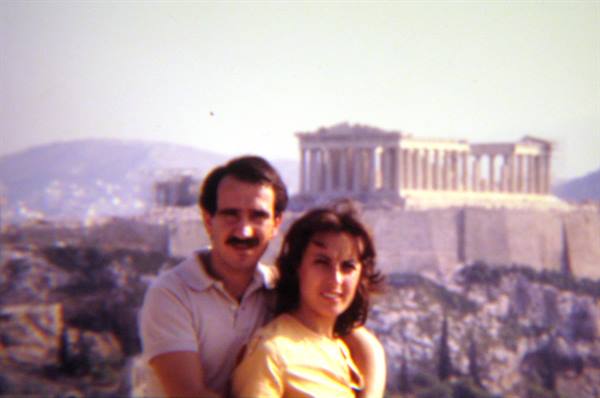 Smiling couple posing in front of the Parthenon on the Acropolis