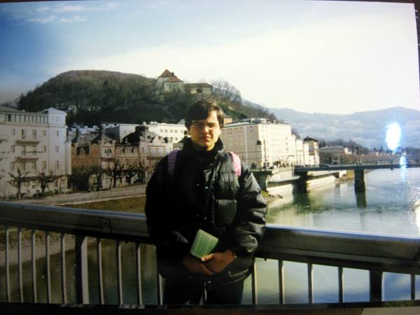Tourist in black jacket on a bridge over the Salzach river, Salzburg