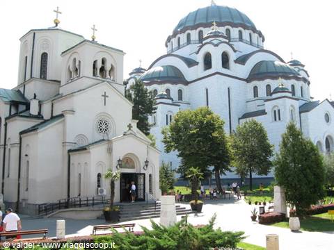White church and large green-domed cathedral in Belgrade