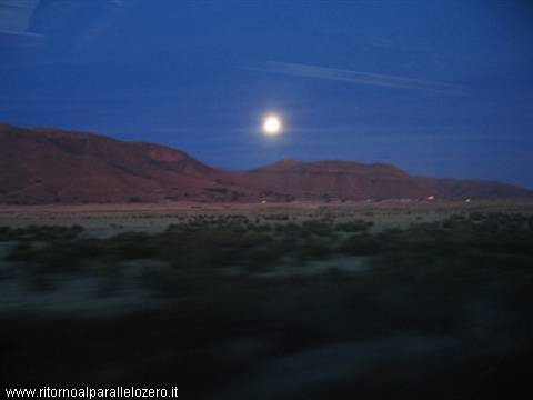 The moon rises from the mountain