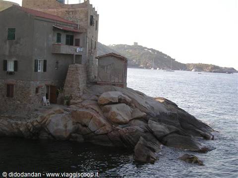 Stone houses perched on granite rocks at Giglio Island harbor