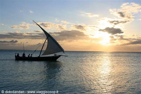 Sailboat with fishermen off Zanzibar coast, golden light on ocean