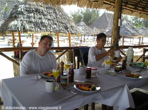 Breakfast under thatched beach bar with straw umbrellas on the sand