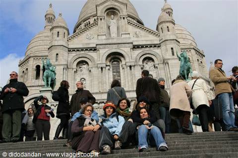 Tourists sitting on the steps of the Sacré-Cœur basilica in Paris