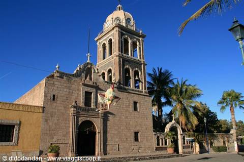Stone mission church with bell tower and dome in Loreto