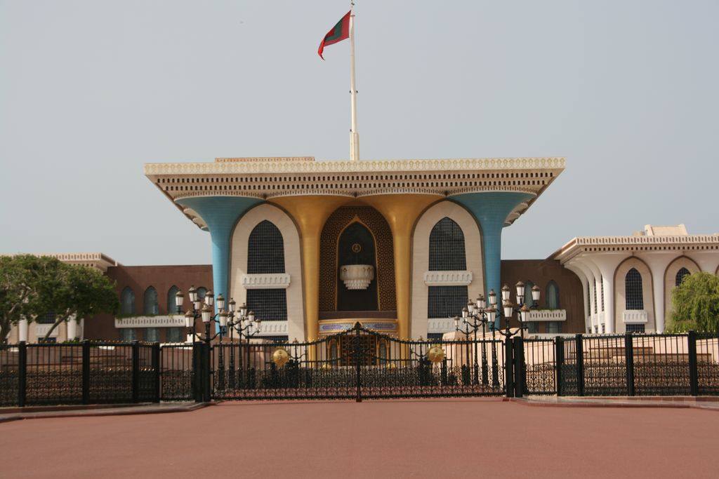 Al Alam Palace in Muscat, blue and golden facade with Omani flag