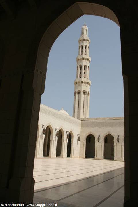 Sultan Qaboos Grand Mosque minaret framed through a stone arch