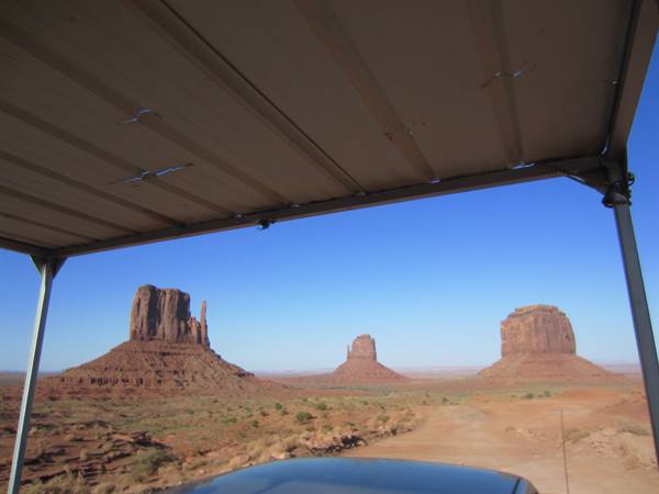 Monument Valley sandstone buttes seen from beneath a metal canopy