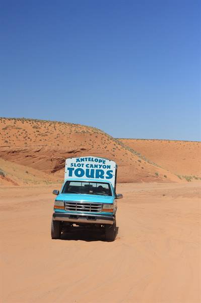 Blue Antelope Slot Canyon Tours truck on red desert sand