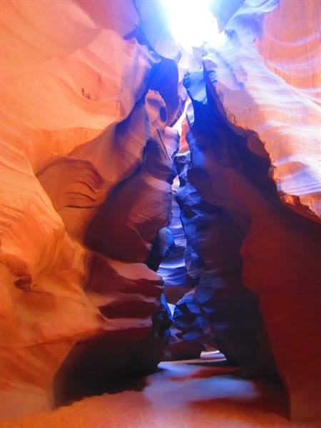 Antelope Canyon: carved sandstone walls, sunlight from above, blue shadows