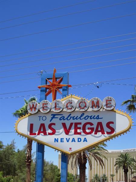 Welcome to Fabulous Las Vegas sign with orange star, palm trees, blue sky