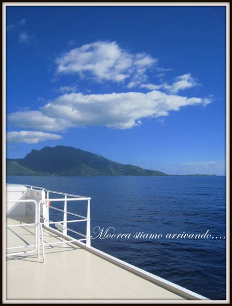 Approaching Moorea island by ferry under white clouds
