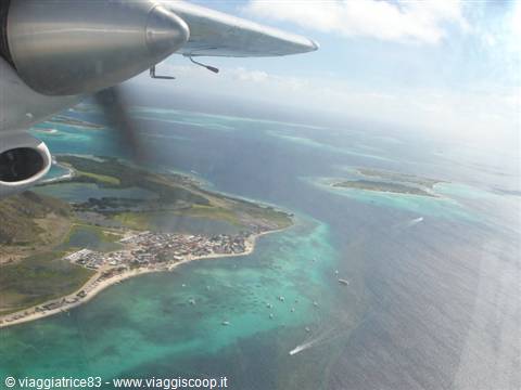 Small plane wing over the turquoise lagoon and islands of Los Roques