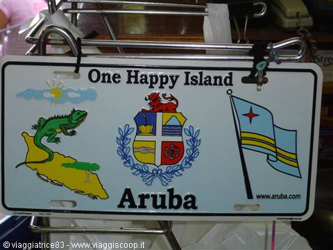 White Aruba license plate with iguana, coat of arms and flag, hanging on a rack