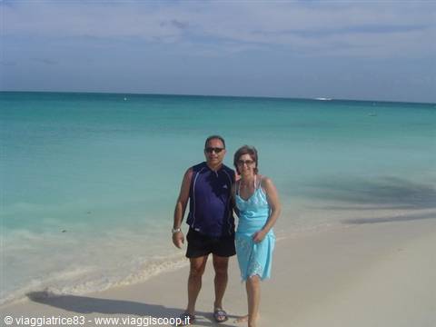 Couple standing on white sand by turquoise sea, Varadero