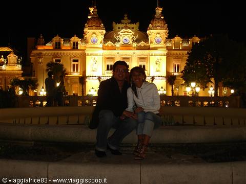 Couple sitting at night in front of the illuminated Monte Carlo Casino