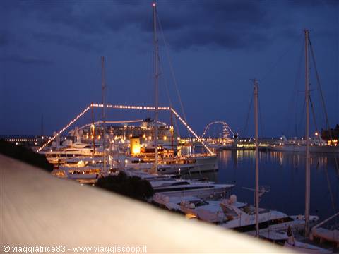 Marina at dusk: illuminated yachts and masts moored in the harbor