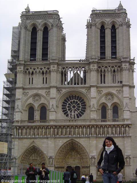 Tourist in front of Notre-Dame's Gothic facade with rose window and twin towers