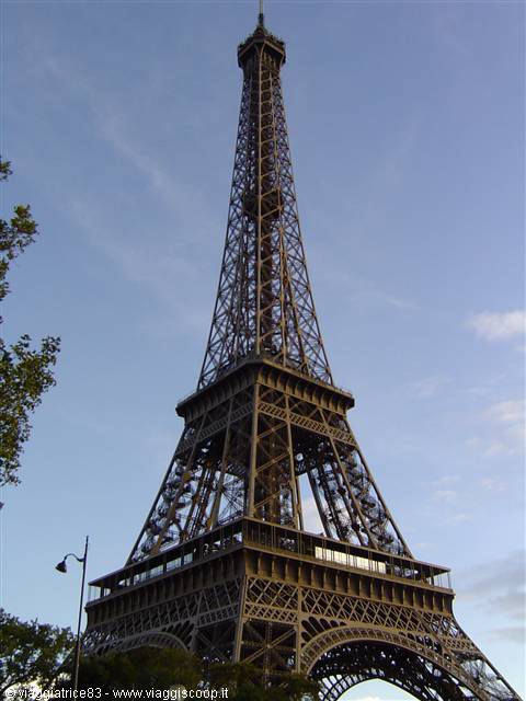 The wrought-iron Eiffel Tower against a blue sky