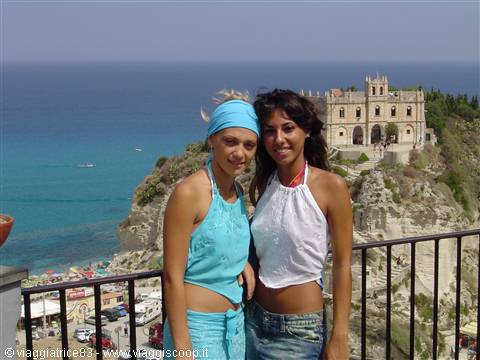 Two smiling girls in front of Santa Maria dell'Isola sanctuary in Tropea
