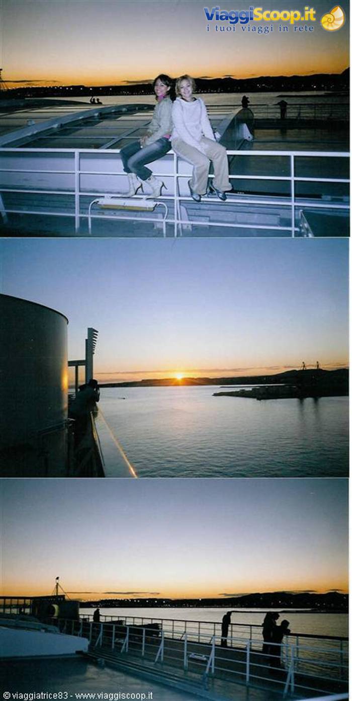 Two women sitting on ferry deck at sunset over the bay
