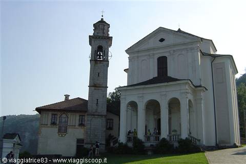 White church with arched portico and tall stone bell tower