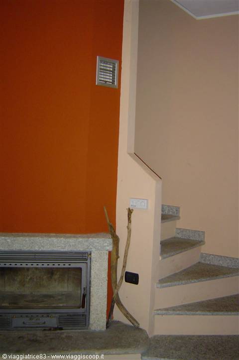 Granite fireplace next to marble stairs, orange and pink walls