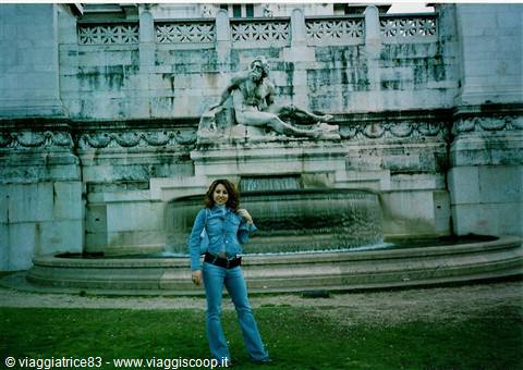 Woman in jeans posing in front of marble statue and fountain in Rome