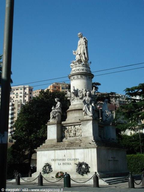 Marble monument to Christopher Columbus crowned by statue, wreaths at its base