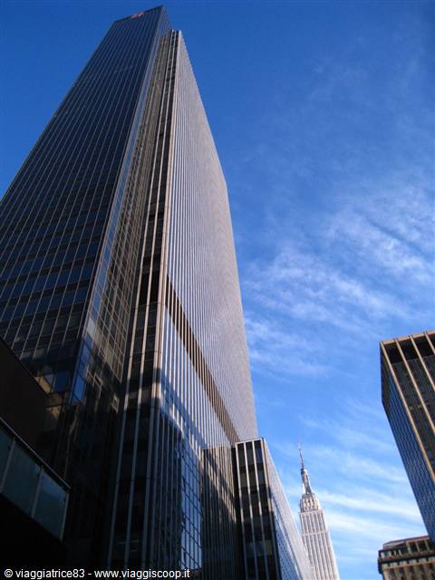 Glass skyscrapers in New York, the Empire State Building touched by clouds