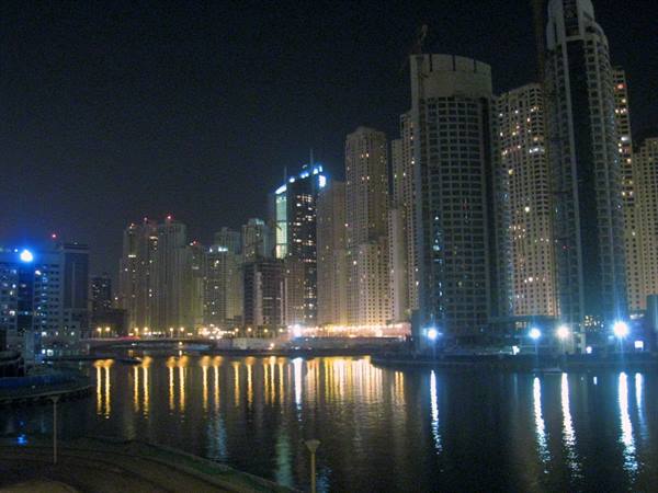 Illuminated Dubai Marina skyscrapers reflected in the marina waters at night