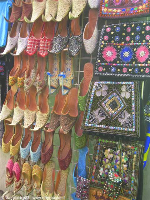 Embroidered slippers and colorful decorated bags hanging in a souvenir shop