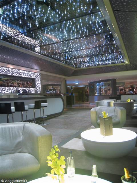 Lounge with bar, white armchairs and ceiling lights resembling a galaxy