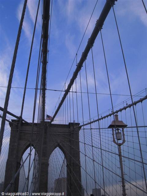Steel cables and lamppost of the Brooklyn Bridge against blue sky