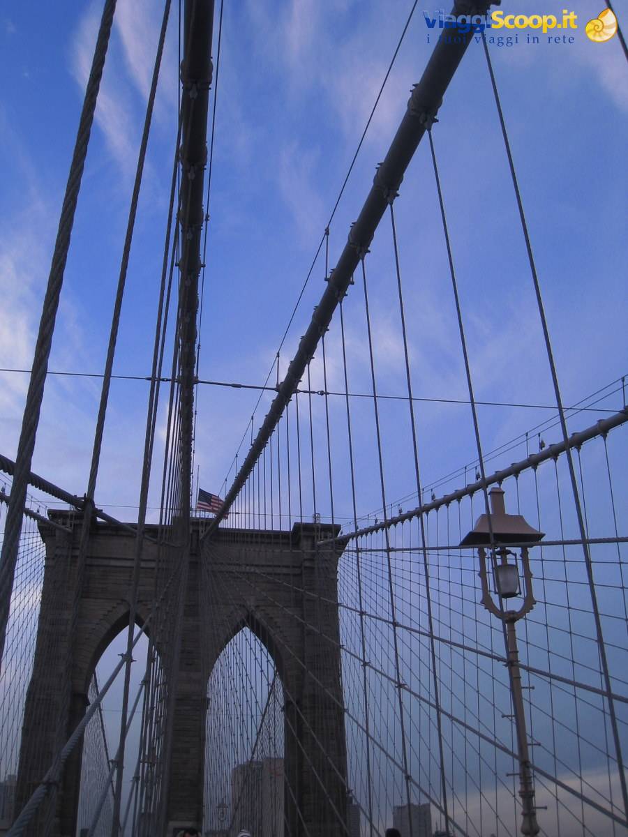 Steel cables and lamppost of the Brooklyn Bridge against blue sky