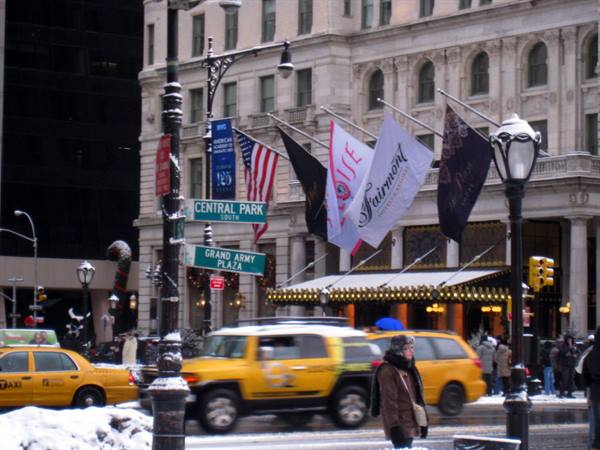 Fairmont Plaza flags by Central Park signs, yellow taxis in snow