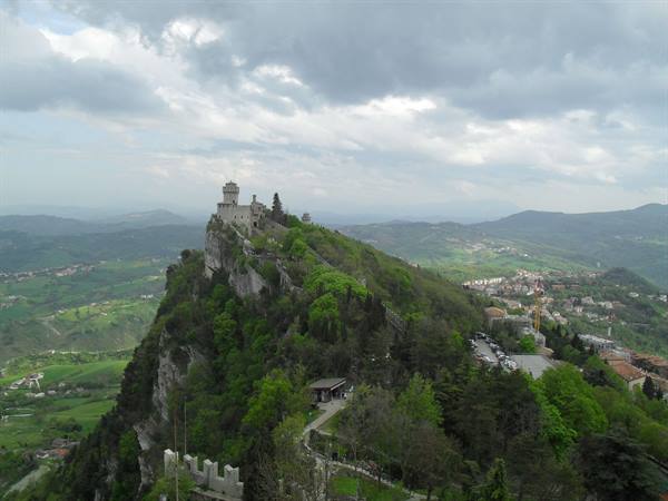 Guaita tower on San Marino's rocky ridge under grey clouds