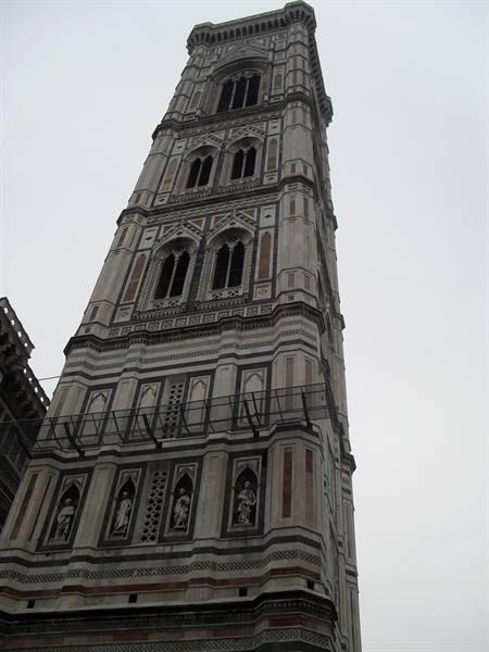 Giotto's bell tower in Florence, white and green marble under grey sky