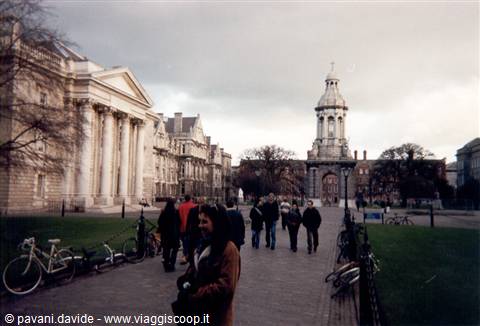 Trinity College Dublin campanile with students and bicycles under a grey sky