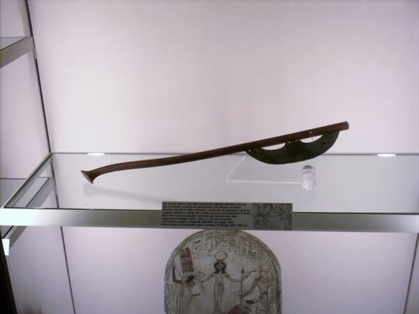 Ceremonial axe with wooden shaft and bronze blade in glass museum case