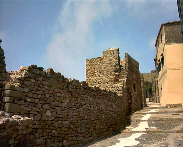 Dry stone walls along an uphill alley between old stone houses