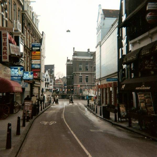 Pedestrian street lined with bars and cafes, people walking, Amsterdam