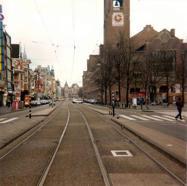 Tram tracks on Amsterdam street, brick tower of the Beurs van Berlage