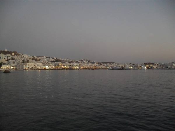 White lit houses along Mykonos harbour seen from the sea