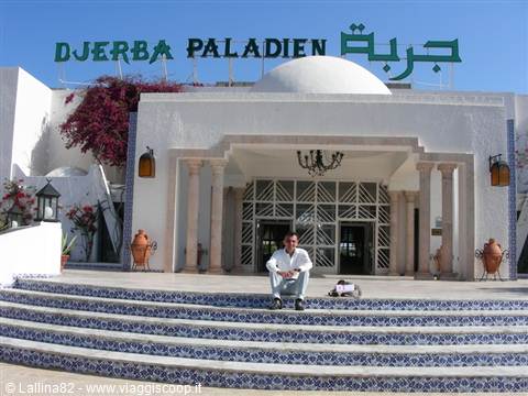 Tourist sitting on blue mosaic steps of the Djerba Paladien hotel entrance