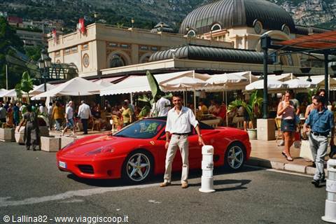 man posing beside a red Ferrari in front of Monte Carlo Casino