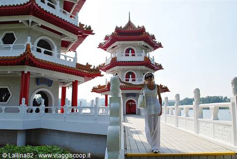 Woman in white walks among white and red pagodas at Singapore Chinese Garden