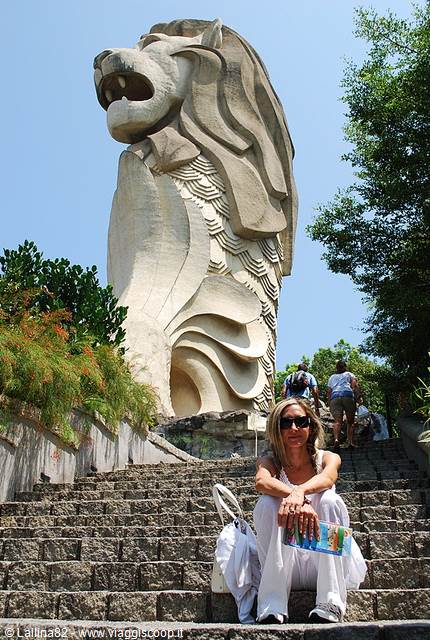 Tourist sitting on the steps in front of the Sentosa Merlion statue